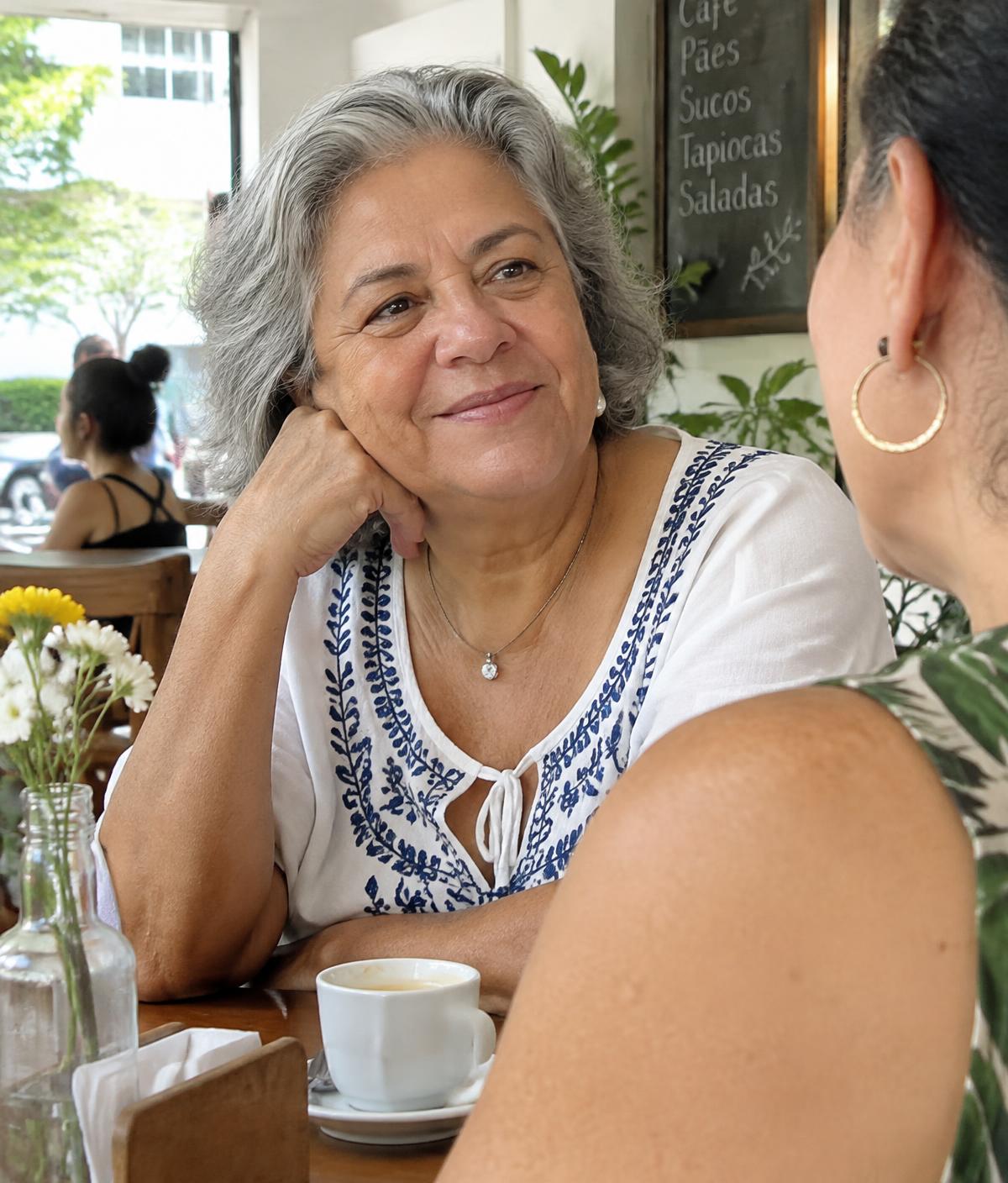 Senhora sorrindo enquanto conversa em um café